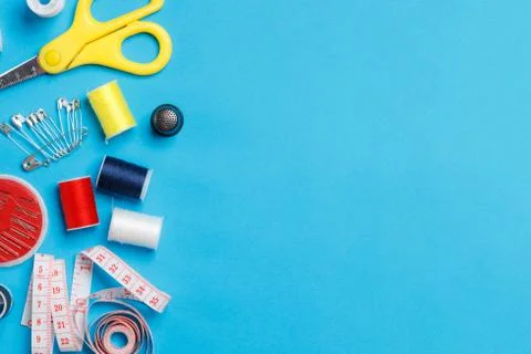Sewing items: tailoring scissors, measuring tape, spools of multicolored thre Stock Photos