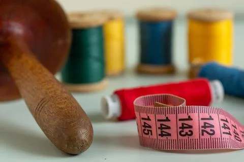 Sewing items - thimble, needle, measuring tape, spools of thread Stock Photos