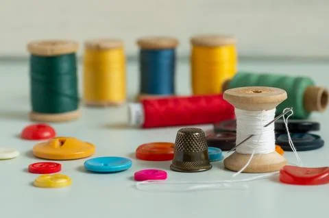 Sewing items - thimble, needle, measuring tape, spools of thread Stock Photos