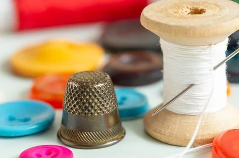 Sewing items - thimble, needle, measuring tape, spools of thread Stock Photos