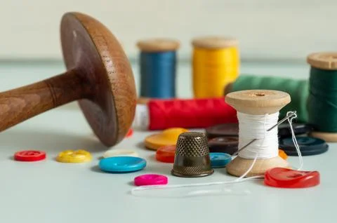 Sewing items - thimble, needle, measuring tape, spools of thread Stock Photos