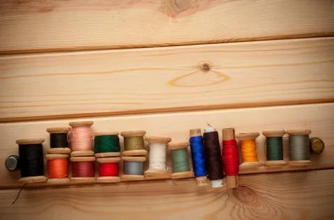 Sewing kit. Scissors, bobbins with thread and needles on the old wooden 写真素材