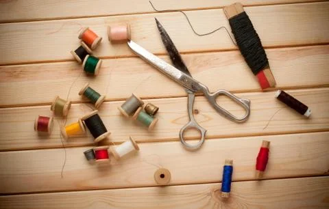 Sewing kit. Scissors, bobbins with thread and needles on the old wooden Foto stock