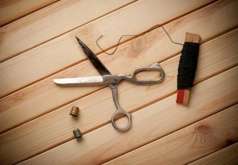 Sewing kit. Scissors, bobbins with thread and needles on the old wooden 写真素材
