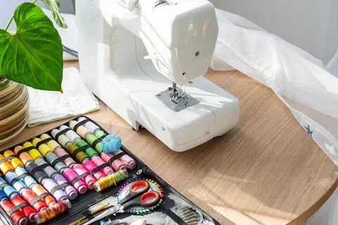 Sewing layout with multicolored spools of thread close-up, needles, electri.. Foto stock