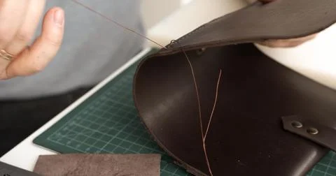 Sewing leather bag with strong thread and needle, artisan crafting process Stock Photos