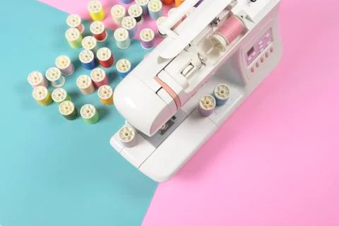 Sewing machine and colorful thread rolls for sewing on two tone background, S Stock Photos