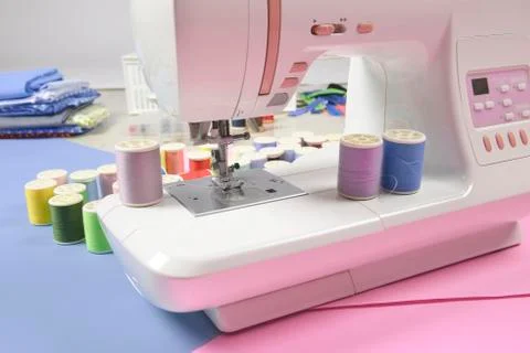 Sewing machine and colorful thread rolls for sewing on two tone background, S Stock Photos