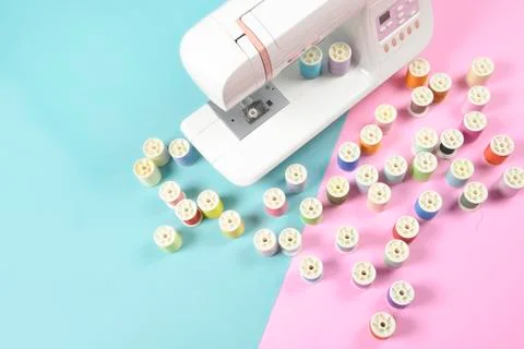 Sewing machine and colorful thread rolls for sewing on two tone background, S Stock Photos