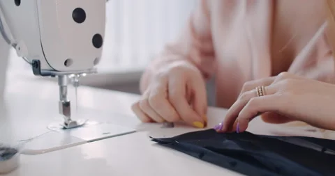 Sewing machine and the hands of an employee sewing in the workshop. Slow motion. Stock Footage 150873791