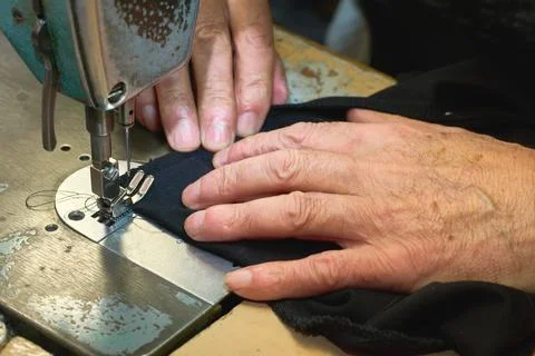 Sewing machine and working hands of a tailor Stock Photos