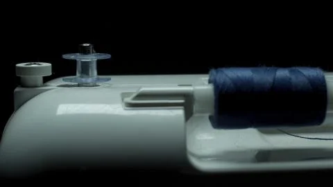 Sewing machine on a black background, appears from the darkness Stock Photos