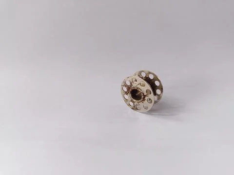 The sewing machine bobbin is rusty. White background. Stock Photos
