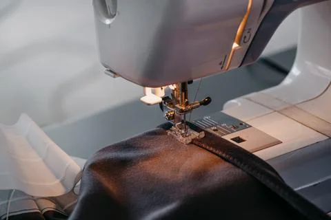 Sewing machine, close-up of a needle and black fabric. Stock Photos