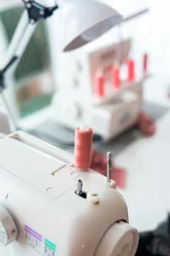 Sewing machine with coils of coral thread . close-up threads. Stock Photos