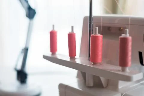 Sewing machine with coils of coral thread . close-up threads. Stock Photos