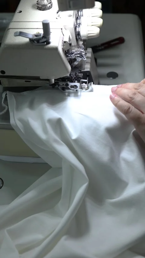 Sewing machine, fabric in hands, stitching process in garment industry, a craft Stock Footage 300204565