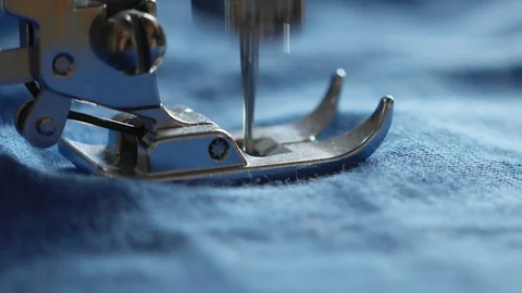 Sewing machine foot close-up. Blue fabric sewing, the fabric covers the camera Stock Footage 128830349