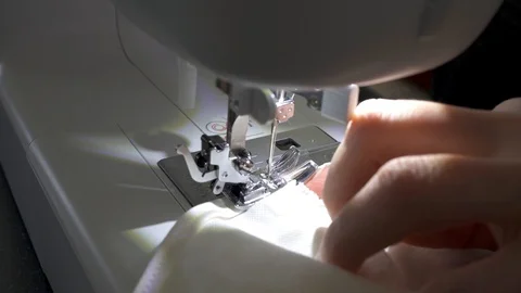 Sewing machine, hands preparing a white mask to protect themselves from Covid-19 Stock Footage 127040909