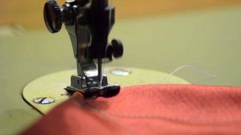 Sewing machine knitting a red fabric Stock Footage 86990611