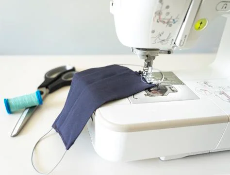 Sewing machine making safety washable face mask during pandemic virus Stock Photos