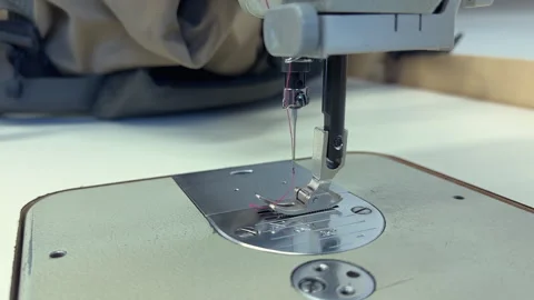 Sewing machine needle in action, stitching fabric on a work surface Vídeos de archivo 343379590