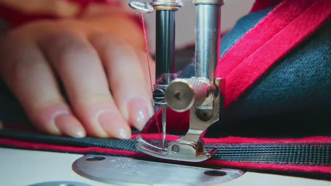 Sewing machine needle pierces fabric with hands guiding material Stock Footage 333750145