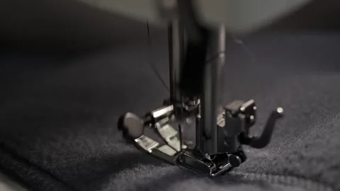 Sewing machine needle repeatedly pierces blue fabric in slow motion Stock Footage 289823953