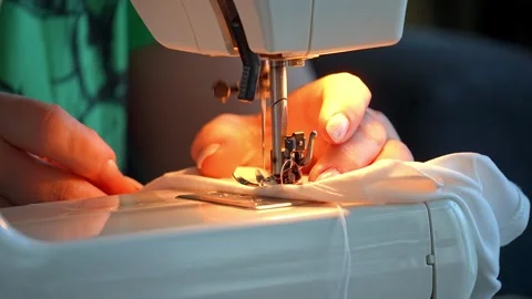 Sewing machine needle repeatedly pierces blue fabric in slow motion Stock Footage 311993176