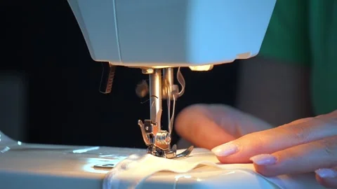 Sewing machine needle repeatedly pierces blue fabric in slow motion 库存影片 311993352