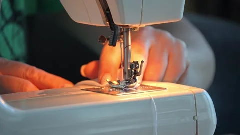 Sewing machine needle repeatedly pierces blue fabric in slow motion 库存影片 311993394