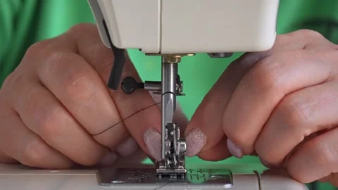 Sewing machine needle repeatedly pierces blue fabric in slow motion 库存影片 311993556