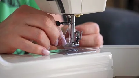 Sewing machine needle repeatedly pierces blue fabric in slow motion Stock Footage 311993901
