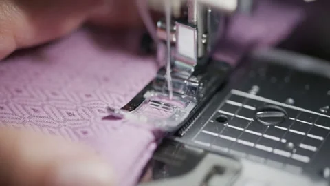 Sewing machine needle stitching patterned pink fabric macro Stock Footage 344382095