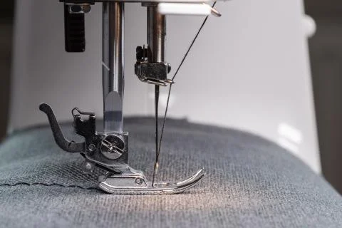 A sewing machine needle with thread. Sewing equipment. Close-up of the workin Stock Photos