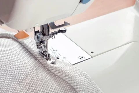 Sewing machine. the process of sewing a decorative cord of white fabric. Stock Photos