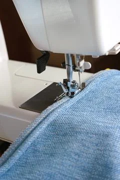 Sewing machine. the process of sewing a decorative cord of blue fabric. Stock Photos