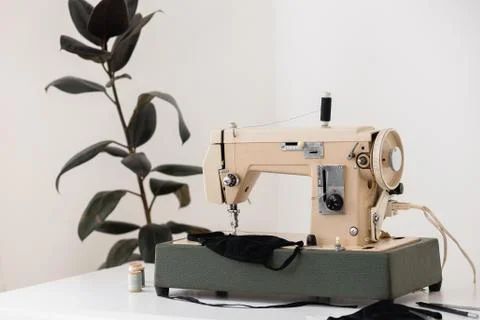 Sewing machine the process of sewing a protective medical mask at home workplace Stock Photos