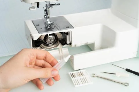 Sewing machine repair, hand with engine oil, diagnostics Stock-Fotos