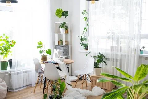 Sewing machine on a round table in the white interior of the house near the.. Stock Photos