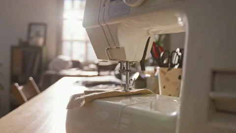 Sewing Machine Standing on Wooden Table in Sunlit Home Workshop Stock Footage 341939264