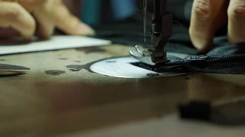 A sewing machine stitches fabric in close view near visible metal machine parts. Stock Footage 339279839