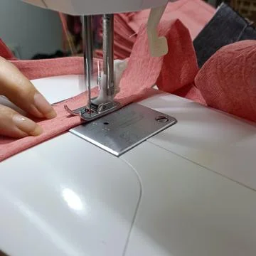 Sewing machine stitching fabric with hands detail Stock Photos
