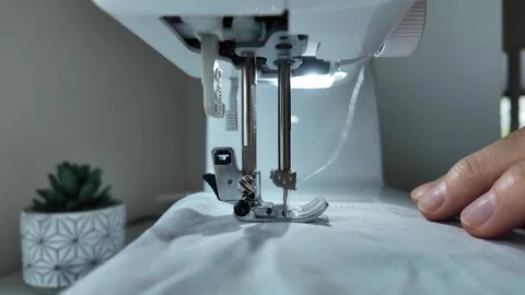 Sewing machine stitching white fabric in home workshop close up Video stock 333306917