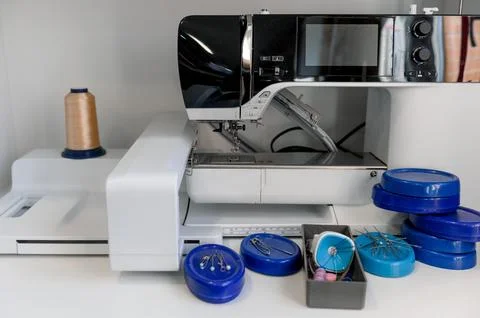 Sewing machine with thread and accessories on workspace table Foto stock