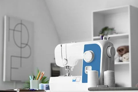 Sewing machine with thread spools on tailor's table in atelier Stock Photos