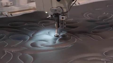 Sewing machine is in use on a black fabric. The machine is making a pattern o Stock Footage 304250719