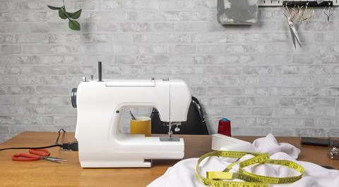 Sewing machine work table with tailoring tools Stock Photos