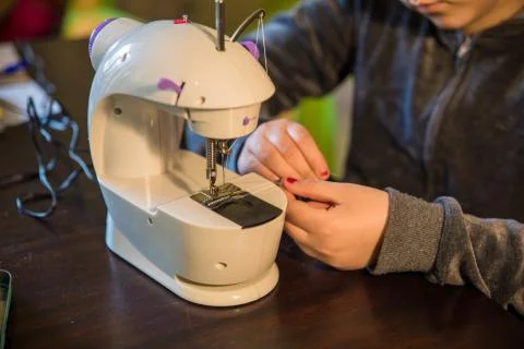 Sewing machine working on a pair of jeans Stock Photos