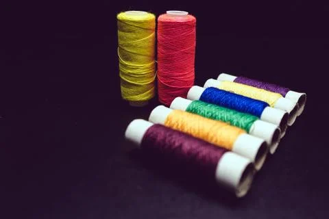 Sewing multi-colored threads on a black background Foto stock